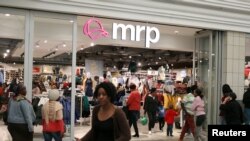 FILE - Shoppers walk past South Africa's Mr Price clothing store in Johannesburg. First National Bank of South Africa says its cardholders made purchases worth more than 2.5 billion rand last Black Friday, and a sizable jump was expected this year.