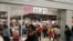 FILE - Shoppers walk past South Africa's Mr Price clothing store in Johannesburg. First National Bank of South Africa says its cardholders made purchases worth more than 2.5 billion rand last Black Friday, and a sizable jump was expected this year.