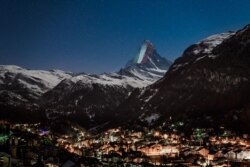 The iconic Matterhorn mountain is illuminated by Swiss light artist Gerry Hofstetter "with a giant Italian flag as a sign of hope and solidarity" amid the COVID-19 pandemic, April 1, 2020.
