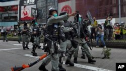 La policía antidisturbios usa gas pimienta contra los manifestantes cuando uno deja caer su arma durante una manifestación contra la legislación de seguridad nacional de Beijing en Causeway Bay en Hong Kong, el domingo 24 de mayo de 2020.