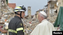 Le pape François parle avec un pompier à Amatrice, Italie, le 4 octobre 2016.