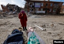 Local resident Lyudmila Timura, 72, mourns over the body of her granddaughter Lera Sukhanova, 15, who was killed by recent shelling in the settlement of Panteleimonivka in the Donetsk region, Russian-controlled Ukraine, Feb. 17, 2024.