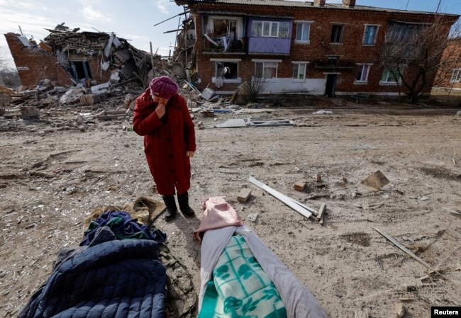 Local resident Lyudmila Timura, 72, mourns over the body of her granddaughter Lera Sukhanova, 15, who was killed by recent shelling in the settlement of Panteleimonivka in the Donetsk region, Russian-controlled Ukraine, Feb. 17, 2024.
