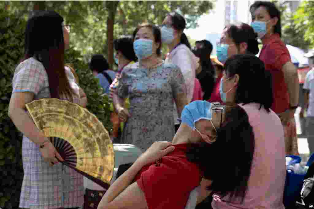 중국 신종 코로나바이러스 감염증(COVID-19) 여파로 한 달간 연기됐던 대학 입학시험 &#39;가오카오&#39;가 개시된 가운데 베이징의 학교 앞에서 수험생의 부모들이 마스크를 착용한 채 서 있다. 