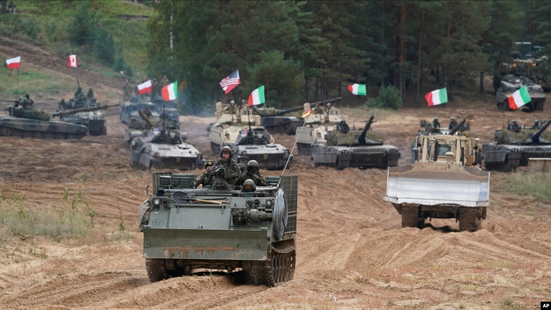 FILE - Military vehicles and tanks of Poland, Italy, Canada and the US participate in NATO military exercises in Kadaga, Latvia, Sept. 13, 2021.