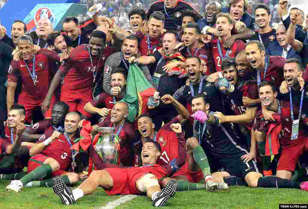  Cristiano Ronaldo deita-se na relva com os seus colegas à volta festejando a taça da UEFA EURO 2016 no Estádio de França em Saint-Denis