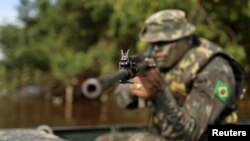 A Brazilian army soldier patrols the border with Colombia during a training to show efforts to step up security along borders, in Vila Bittencourt, Amazon state, Brazil, Jan. 18, 2017.