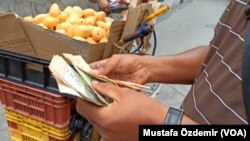 Caracas'ta bir sokak satıcısı para sayarken