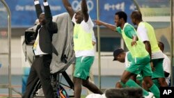 Nigeria's head coach Samson Siasia, left, and his team members celebrate after defeating Belgium 4-1 in a men's semifinal soccer match between Belgium and Nigeria at the Beijing 2008 Olympics in Shanghai, Tuesday, Aug. 19, 2008. (AP Photo/Eugene Hoshiko)