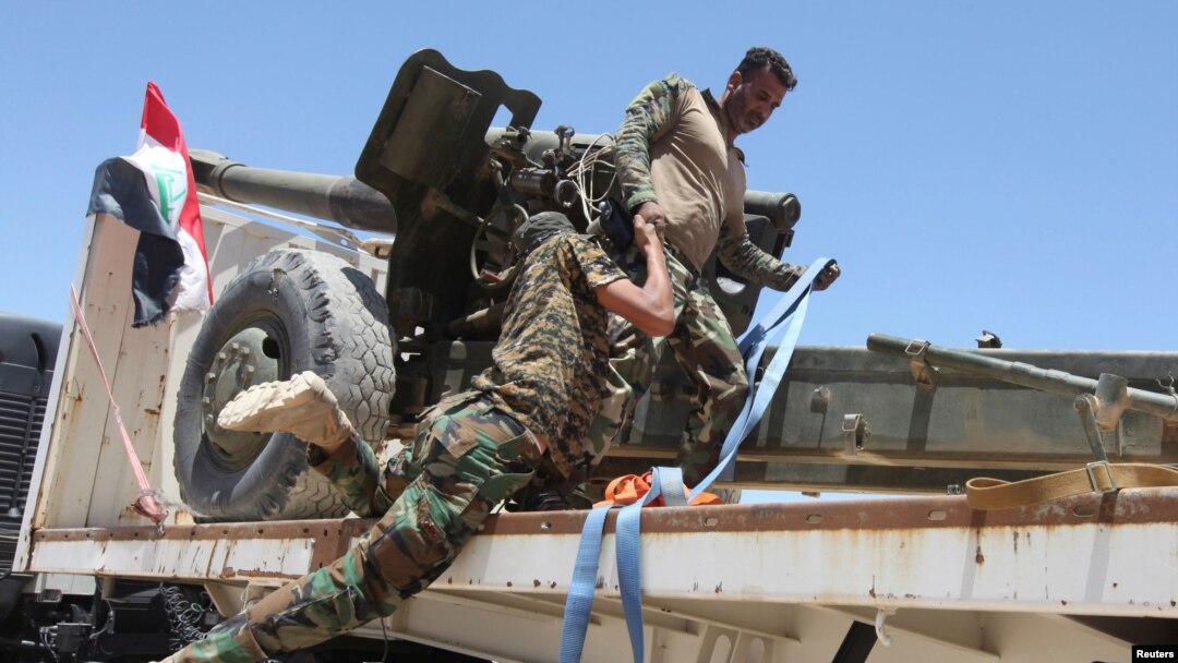 Thành viên lực lượng an ninh Iraq giúp đồng đội lên xe ở ngoại ô Fallujah, Iraq, ngày 11/6/2016.