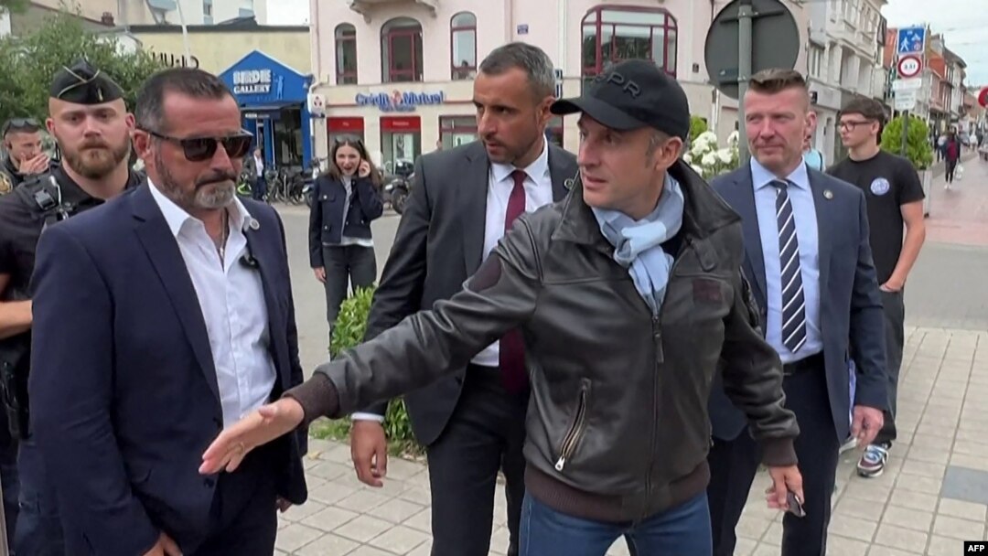 Francuski predsednik Emanuel Makron rukuje e sa ljudima 29. juna 2024. na ulici u Le Tuke Pari Plažu, u severnoj Francuskoj, na fotografii napraljenoj od video snimka.