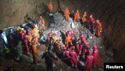 Tim SAR berkerumun di lokasi ditemukannya penyintas, Tian Zeming (19 tahun) di bawah reruntuhan gedung yang robot akibat tanah longsor di Shenzhen, provinsi Guangdong (23/12).