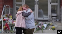 Leah Fauth gets a hug after leaving flowers in front of the West York Police Department after a police officer was killed responding to a shooting at UPMC Memorial Hospital in York, Pa., on Feb. 22, 2025. 