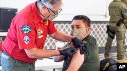 지난 5일 미국 캘리포니아주 포모나에서 주보안관들이 신종 코로나바이러스 백신 접종을 하고 있다.