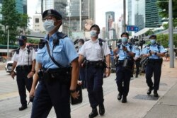 Police officers patrol outside a court July 30, 2021, as they wait for Tong Ying-kit to leave the court in Hong Kong after sentencing for the violation of a security law during a 2020 protest. Tong was sentenced to nine years in prison.