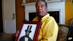 Ocea Thomas poses with a portrait of her ancestor, Samuel Burris, a free black man convicted of helping slaves escape in the 19th century. Gov. Jack Markell expects to pardon Burris, who died in 1863.