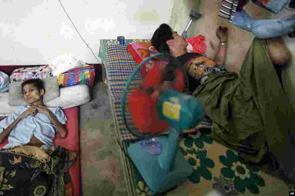 A terminally ill patient and an amputee who lost legs to land mines, both from Burma, rest at the Mae Tao clinic in Mae Sot, in northwest Thailand, October 13, 2010.