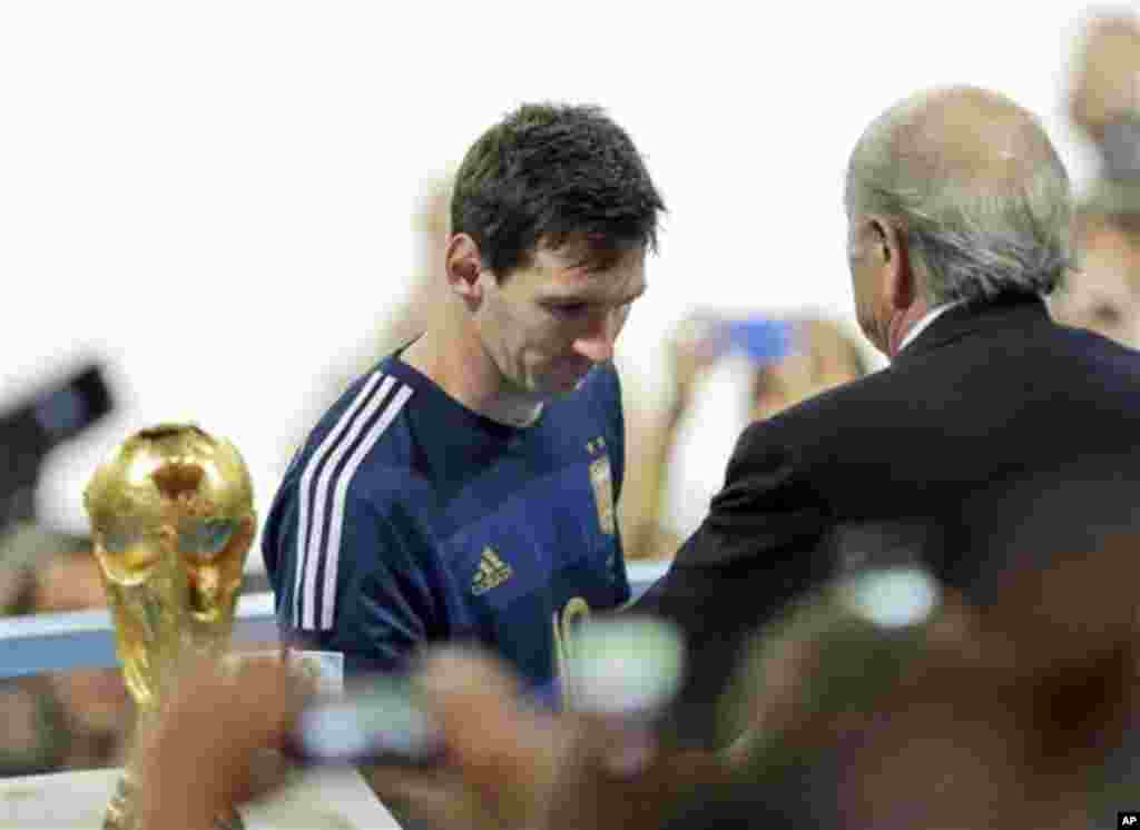 Argentina's Lionel Messi collects the second place trophy after the World Cup final soccer match between Germany and Argentina at the Maracana Stadium in Rio de Janeiro, Brazil, Sunday, July 13, 2014. Germany won 1-0.(AP Photo/Hassan Ammar)