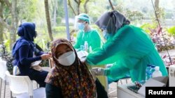 Seorang perempuan divaksin COVID-19 di Jakarta, 8 Juli 2021. Pemerintah Indonesia meningkatkan vaksinasi dengan memobilisasi van vaksin. (Reuters)