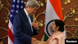 Menlu AS John Kerry (kiri) berjabat tangan dengan Menlu India Sushma Swaraj sebelum pertemuan di New Delhi, India hari Selasa (30/8). 