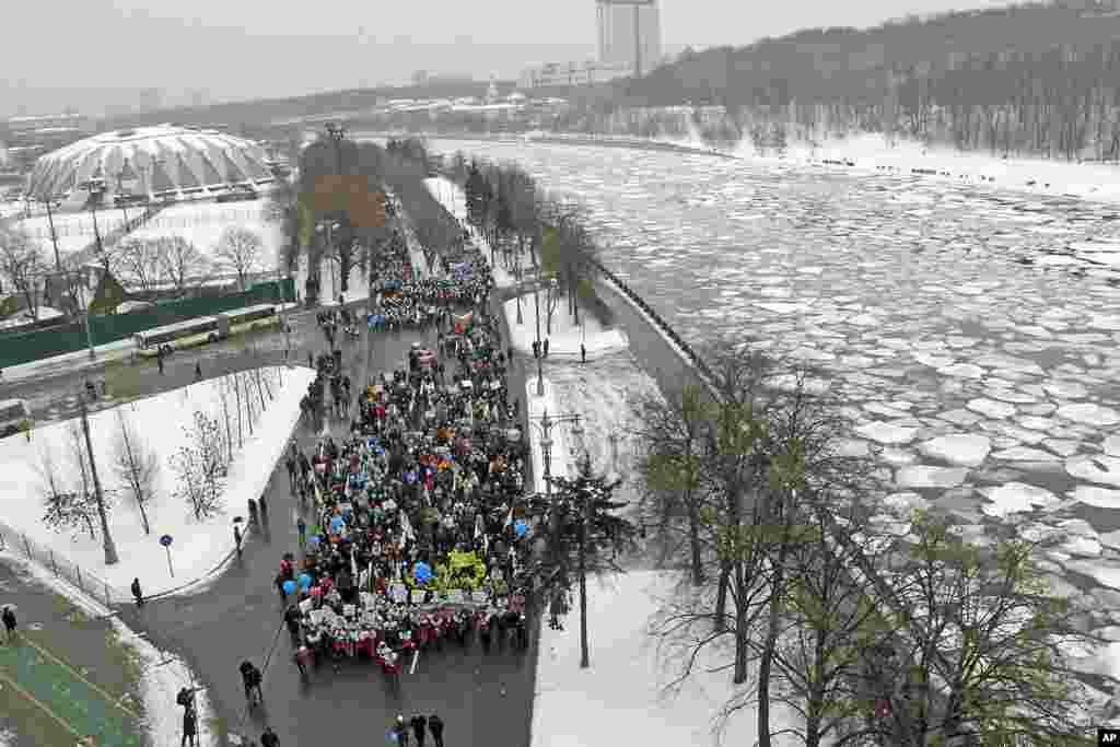 People take part in a procession along Frunzenskaya quay to support presidential candidate and Russia's current Prime Minister Vladimir Putin on the Defender of the Fatherland Day near the Moskva River in Moscow, February 23, 2012. (Reuters)