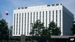 The Russian flag flies on the grounds of the Embassy of the Russian Federation in Washington, Thursday, April 15, 2021. The Biden administration has rolled out a sweeping set of sanctions on Russia over its election interference, hacking efforts and…