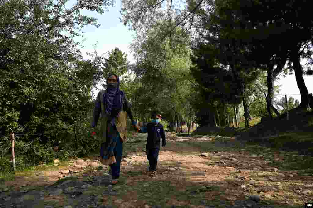 ایک خاتون اپنے بچے کو اسکول چھوڑنے جا رہی ہیں۔