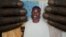 FILE: FILE - In this Feb. 5, 2010 file photo, shopkeeper Ousmane Diallo displays a photo of his son Madieye Diallo, a gay activist whose body was disinterred and desecrated hours after burial, in Thies, Senegal.
