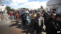 People carry their belongings after they fled Libya at the Tunisia-Libya border, near the village of Ras El Jedir, Tunisia, Feb. 24, 2011