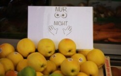 A sign describes "Only look, do not touch" is display near fruits at the city market in Augsburg, Germany, March 23, 2020.