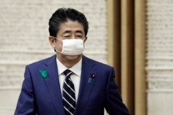 Wearing a protective mask, Japanese Prime Minister Shinzo Abe leaves a news conference at the prime minister's official residence in Tokyo, April 17, 2020.