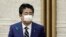 FILE - Wearing a protective mask, Japanese Prime Minister Shinzo Abe leaves a news conference at the prime minister's official residence in Tokyo, April 17, 2020.