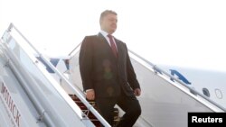 Presiden Ukraina Petro Poroshenko menuruni tangga pesawat saat tiba di Minsk (26/8). 