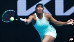 FILE: Venus Williams makes a forehand return to Belgium's Kirsten Flipkens during their first round match at the Australian Open tennis championship in Melbourne, Australia, on Feb. 8, 2021.