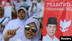 A girl sings a song as she attends Indonesia's presidential candidate Prabowo Subianto campaign rally in Gelora Bung Karno Stadium in Jakarta, June 22, 2014.