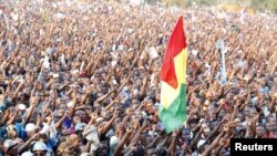 Para pendukung kandidat presiden dari partai oposisi Uganda (FDC), Kizza Besigy membawa bendera mereka dakan kampanye di kota industri Jinja, Uganda (12/2). 