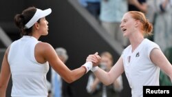 Petenis Belgia, Alison Van Uytvanck, menyalami petenis Spanyol dan juara bertahan, Garbine Muguruza, setelah laga di turnamen tenis Wimbledon, 5 Juli 2018. Van Uytvanck mengalahkan Muguruza dan maju ke putaran ketiga.