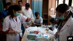 A patient has his blood taken to be tested at a fever clinic especially set up to cater to those suffering from fever, one of the main symptoms of several mosquito-borne diseases such as dengue, at a hospital in New Delhi, India, Sept. 15, 2016. The World Health Organization is continuing to assess the risks and benefits of the first vaccine developed to prevent dengue.