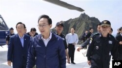 Presiden Korea Selatan Lee Myung-bak (tengah) melakukan kunjungan ke kepulauan Dokdo, yang juga diklaim oleh Jepang, hari Jumat (10/8). 