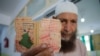 A man shows his voting card at a polling station during the presidential election in Algiers, Algeria, on Sept. 7, 2024.