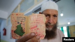 A man shows his voting card at a polling station during the presidential election in Algiers, Algeria, Sept. 7, 2024.