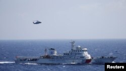 Kapal dan helikopter China dalam latihan pencarian dan penyelamatan dekat pulau Qilian Yu di Kepulauan Paracel atau Xisha, di Laut China Selatan (14/7). 