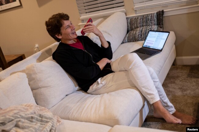 Scientist Carolyn Bertozzi talks with a reporter on the phone after winning one of three Nobel Prize in Chemistry at her home in Palo Alto, California, U.S. October 5, 2022. (REUTERS/Carlos Barria)