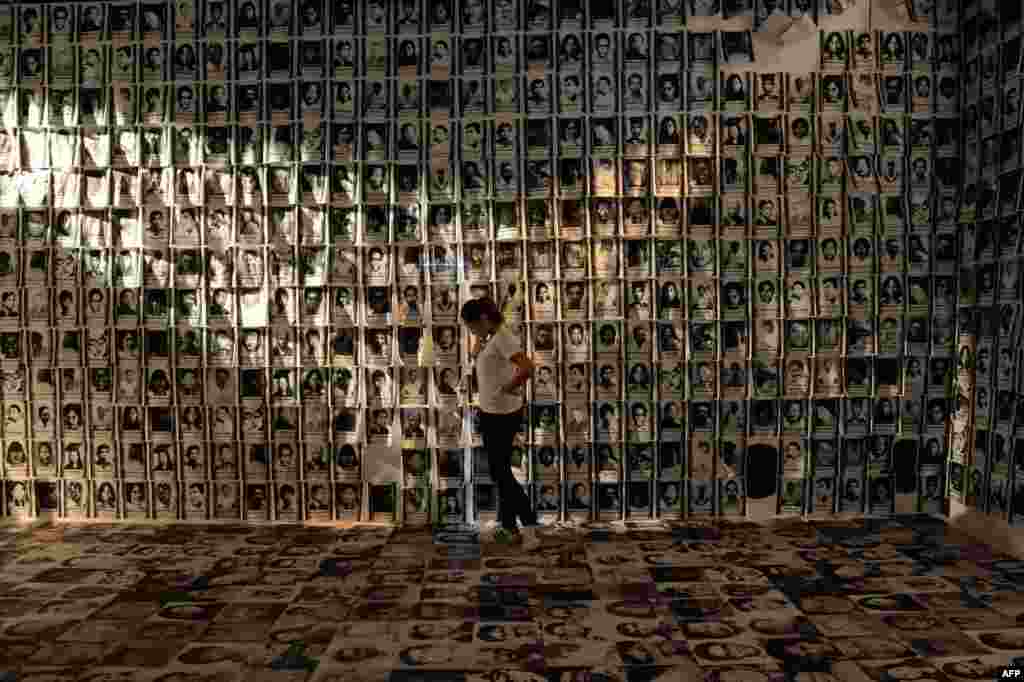 A woman looks at photos of human rights victims during martial law, displayed at an experiential museum inside a military camp in Manila, the Philippines, ahead of the 30th anniversary of people power that toppled dictator Ferdinand Marcos in 1986.