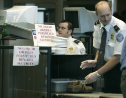 FILE - Transportation Security Administration (TSA) workers screen passenger belongings at a security checkpoint at Washington Dulles International Airport in Chantilly, Virginia.