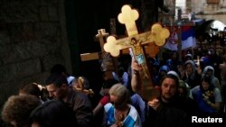 Christian worshippers hold crosses as they take part in a procession along Via Dolorosa on Good Friday during Holy Week in Jerusalem's Old City April 18, 2014. Christian worshippers on Friday retraced the route Jesus took along Via Dolorosa to his crucifi