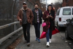 In this Dec. 27, 2019, photo, old college friends and acquaintances Mohammed Ali, left, of Stanton Island, and Saad Khan, center, of New Jersey, and Amani Al-Khatahtbeh, founder of Muslimgirl.com, right, walk to Al-Khatahtbeh's favorite bagel shop.