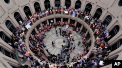 FILE - Members of the transgender community and others who oppose Senate Bill 6 protest in the exterior rotunda at the Texas Capitol as the Senate State Affairs Committee holds hearings on the bill, March 7, 2017, in Austin, Texas. 
