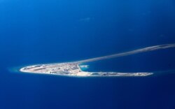 FILE - In this April 21, 2017, file photo, Chinese structures and an airstrip on the man-made Subi Reef at the Spratlys group of islands are seen from a Philippine Air Force C-130 transport plane.