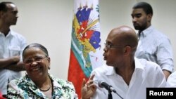 Haiti's presidential candidates Manigat and Martelly speak to each other before a news conference in Port-au-Prince, January 29, 2011.